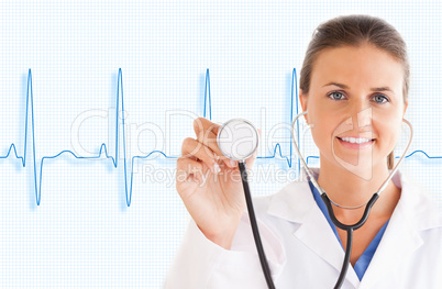 Doctor holding up stethoscope with blue ECG line