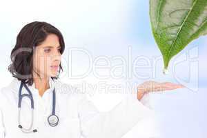 Doctor reaching out to dew drop falling from leaf