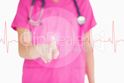 Nurse in pink scrubs touching red ECG line