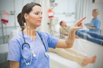 Nurse in hospital ward pointing to something