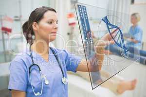 Nurse touching screen displaying blue DNA helix data