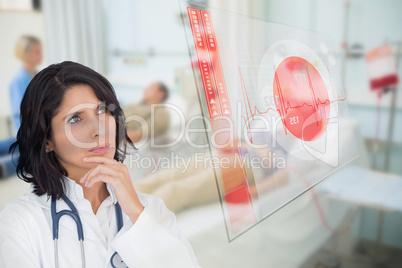 Doctor looking up at screen showing red ECG data