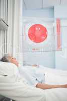 Patient lying in hospital bed with futuristic ECG data display