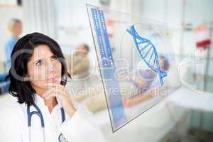 Doctor looking up at screen showing blue DNA helix data