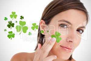 Smiling woman touching shamrocks to face