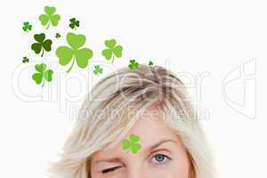 Blonde woman winking on shamrock background