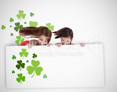 Girls looking down at blank placard with shamrocks Girls looking down at blank placard with shamrocks