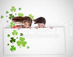 Girls looking down at blank placard with shamrocks