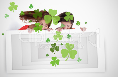 Girls looking down at placard with shamrocks