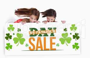 Girls holding placard with st patricks day sale text