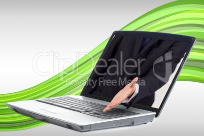 Businessman reaching out from laptop for handshake