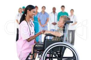 Nurse chatting with little boy in wheelchair