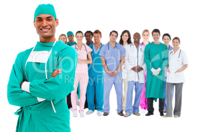 Smiling surgeon with medical staff behind him