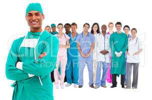 Smiling surgeon with medical staff behind him