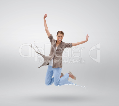 Woman jumping with clothes turning to paint splatters