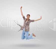 Woman jumping with clothes turning to paint splatters