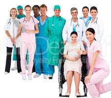 Nurse with pregnant woman in wheelchair with medical staff
