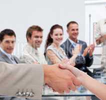 Businessman and woman shaking hands in presentation