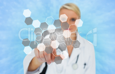 Blonde doctor pressing touchscreen displaying hologram