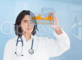 Brunette doctor looking at a graph with futuristic technology