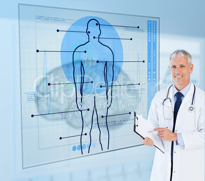 Senior doctor holding a clipboard beside display screens