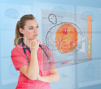 Thoughtful nurse using a futuristic interface Thoughtful nurse using a futuristic interface