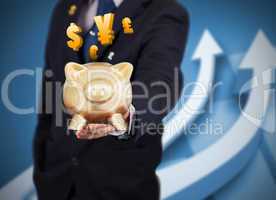 Businessman holding a piggy bank with international currencies