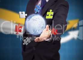 Businessman with colored puzzles and a globe