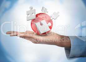 Hand with digital white puzzles and a red globe