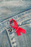 Aids awareness ribbon pinned to jeans