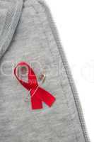 Aids awareness ribbon pinned on to grey hoodie