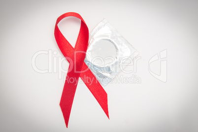 Red Aids ribbon beside condom