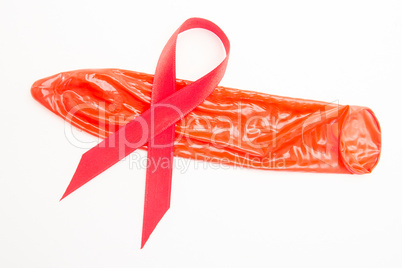 Red awareness ribbon lying on condom