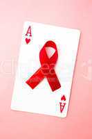 Red awareness ribbon lying on playing card