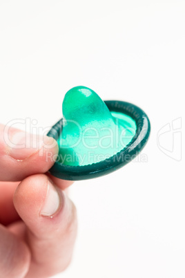 Hand holding green condom