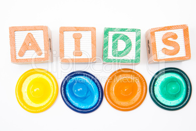 Wood blocks spelling out aids with four condoms