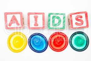 Wood blocks spelling out aids with four colourful condoms