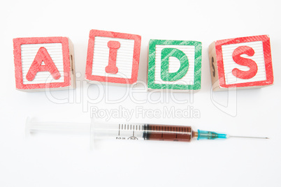 Wood blocks in green and red spelling out aids with syringe