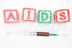 Wood blocks in green and red spelling out aids with syringe