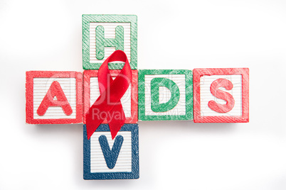 Wood blocks spelling aids and hiv in a cross shape with red awar