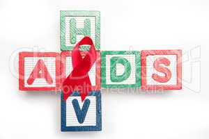 Wood blocks spelling aids and hiv in a cross shape with red awar