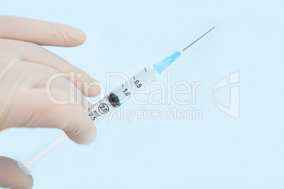 Gloved hand holding syringe