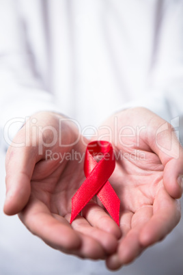 Man holding red aids ribbon