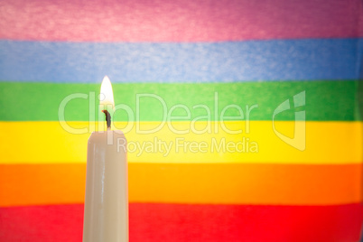 Candle against rainbow flag