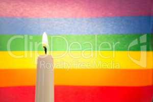 Candle against rainbow flag