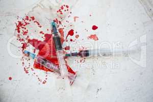 Three syringes in pool of blood