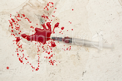 Syringe lying on floor with blood