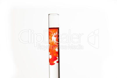 Test tube of water with orange paint