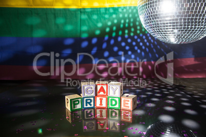 Block spelling gay pride under light of disco ball