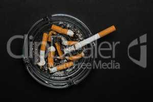 Burning cigarette left in ashtray